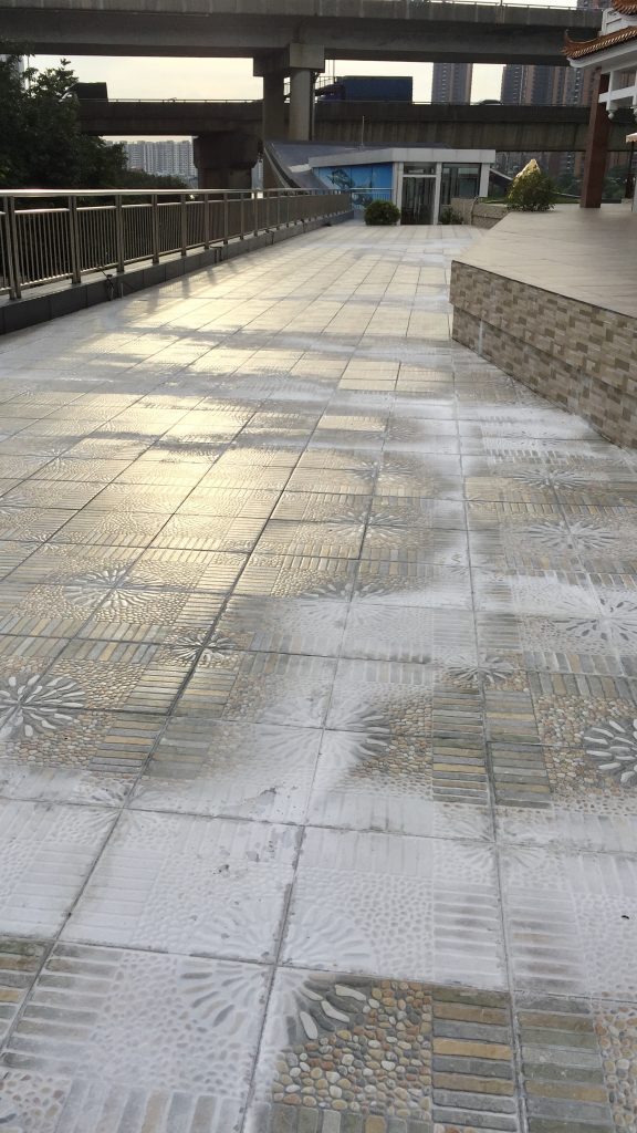 室外地磚在下雨或用大量清水清洗地面後,水經由磁磚縫滲入再溢出,令地面磁磚留下大片白色晶體,出現白華/壁癌現象